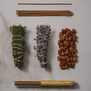 Collection of incense sticks, sage, lavender, and other herbs on a marble surface