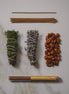 Collection of incense sticks, sage, lavender, and other herbs on a marble surface