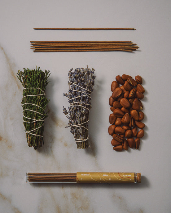 Collection of incense sticks, sage, lavender, and other herbs on a marble surface