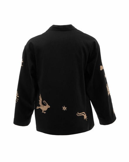 Black top with gold embroidery on a white background