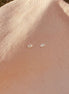 Small earrings on a beige fabric background