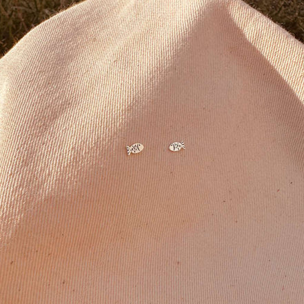 Small earrings on a beige fabric background