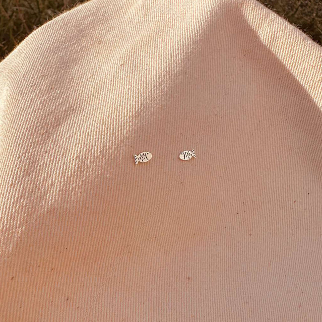 Small earrings on a beige fabric background