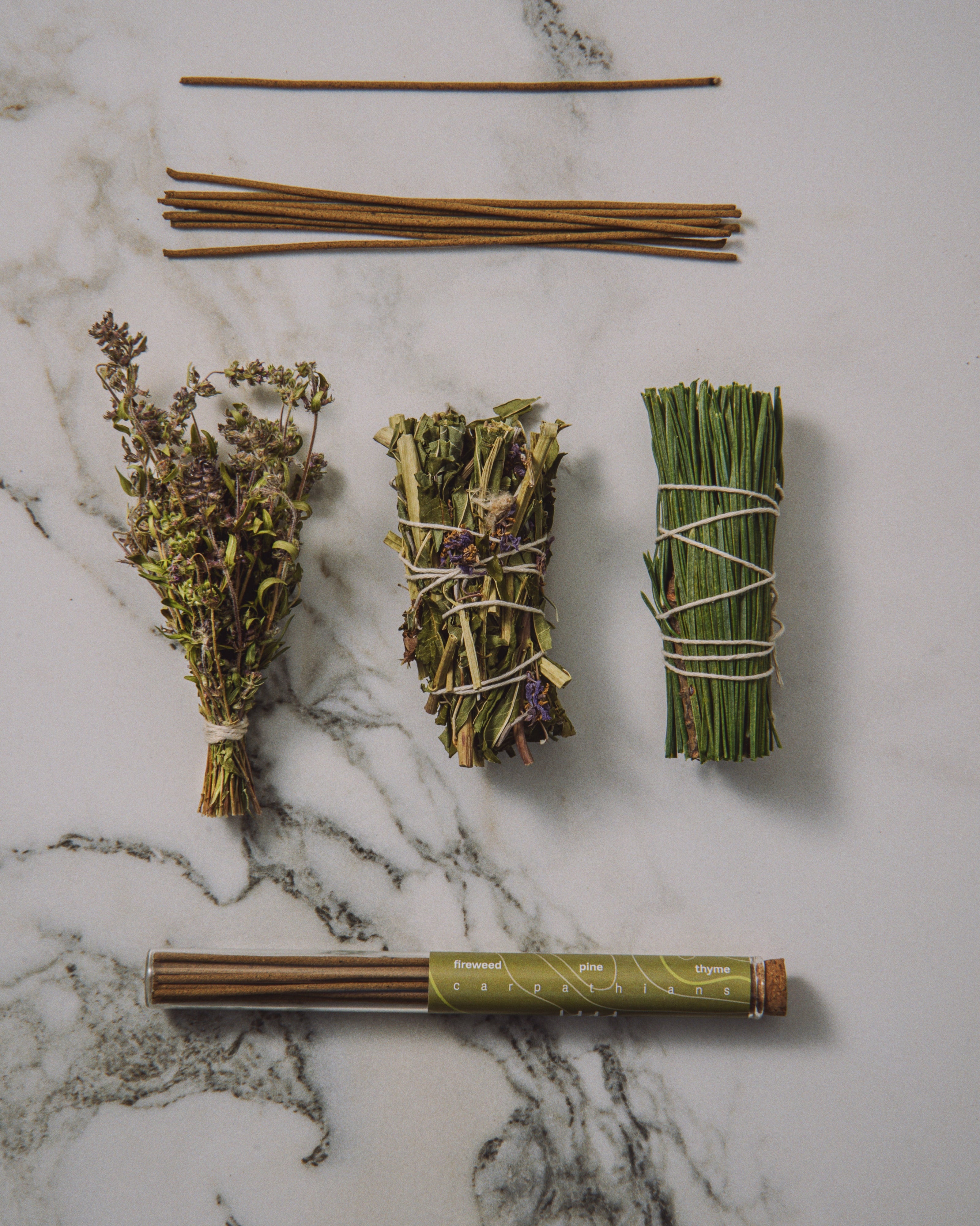 Herbal bundles tied with twine on a marble surface