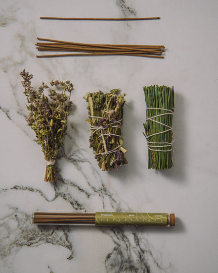 Herbal bundles tied with twine on a marble surface