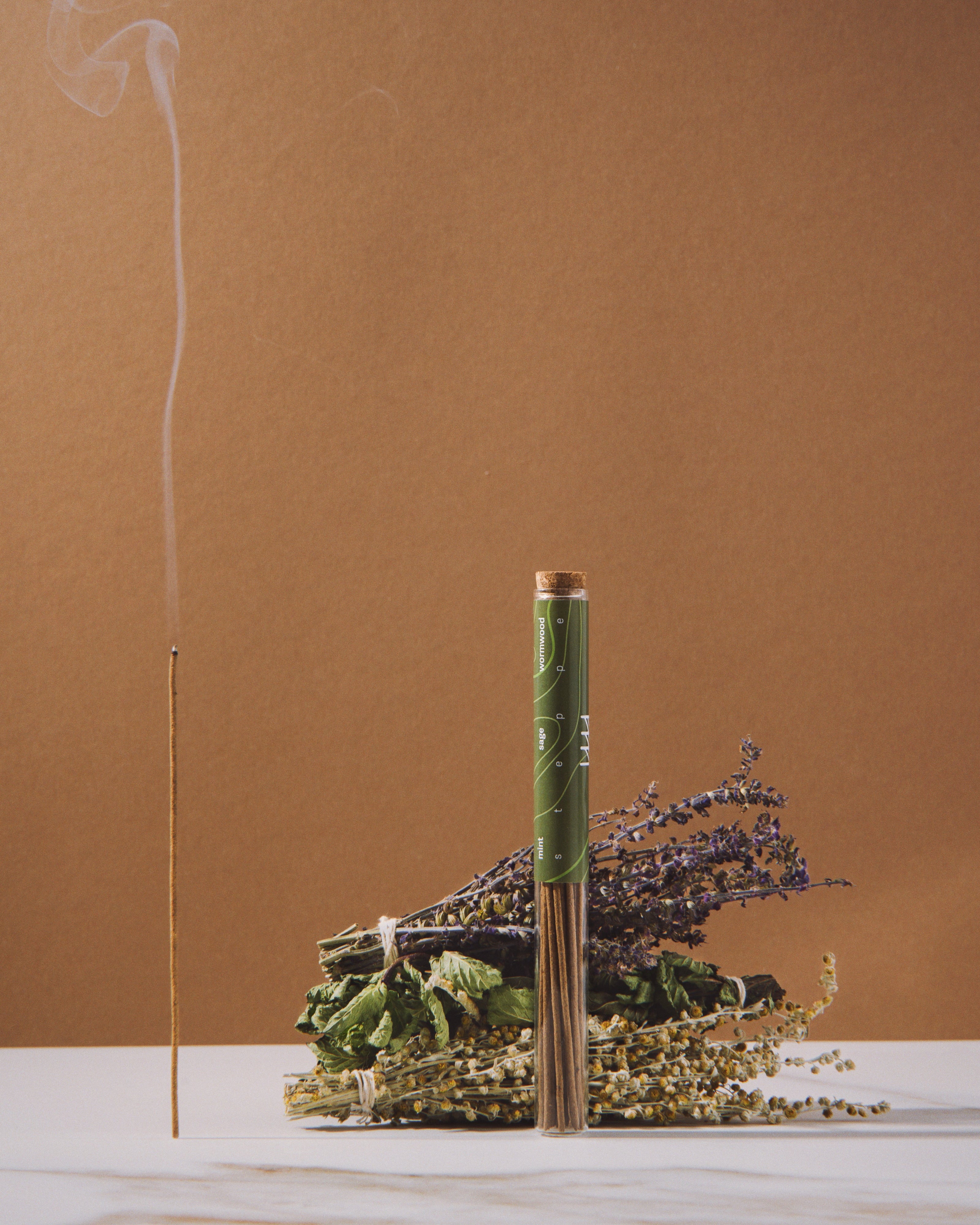 Incense stick with smoke and decorative elements on a brown background