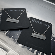 Two necklaces with 'Ukrainian' pendants on black cards with 'denmo jewelry' branding.