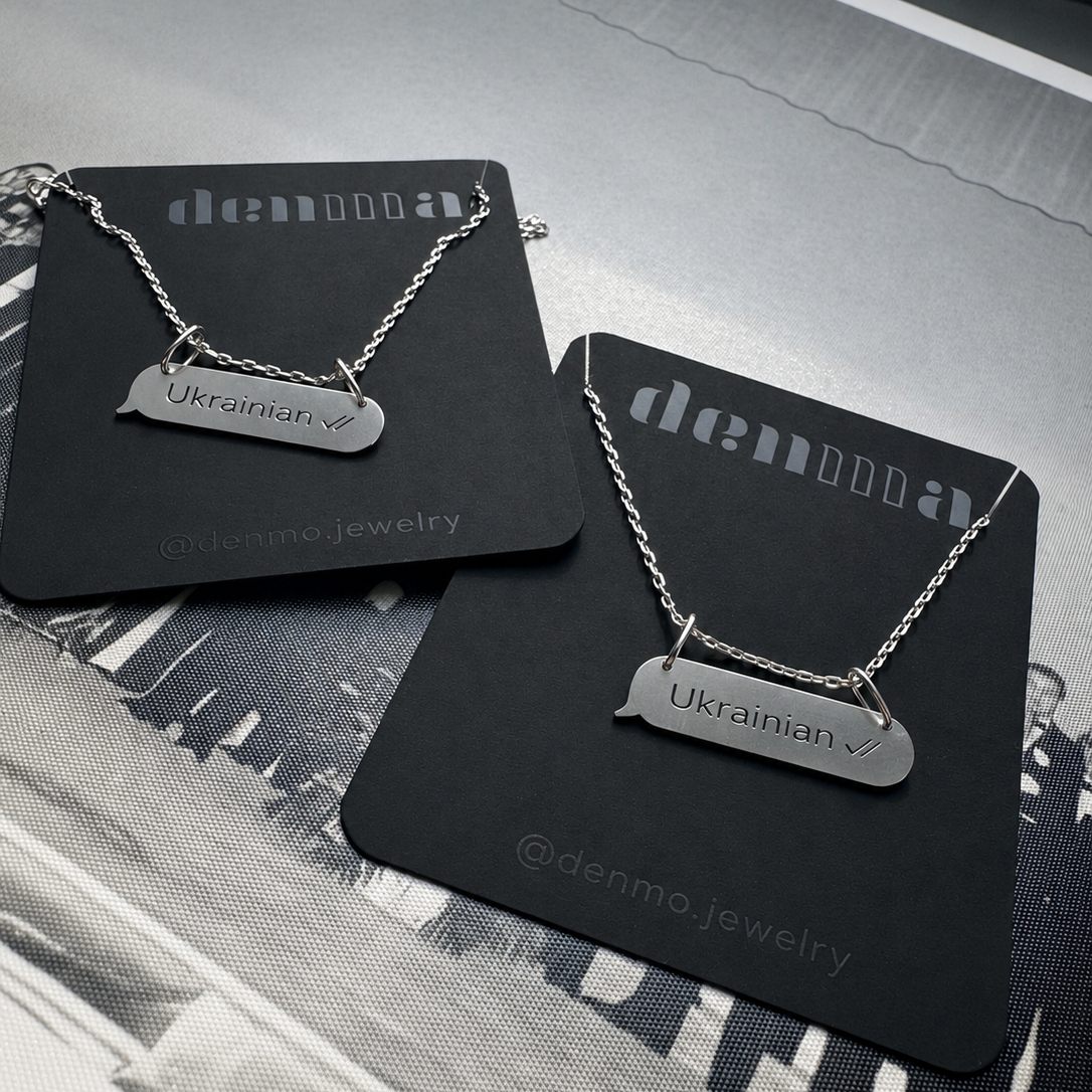 Two necklaces with 'Ukrainian' pendants on black cards with 'denmo jewelry' branding.