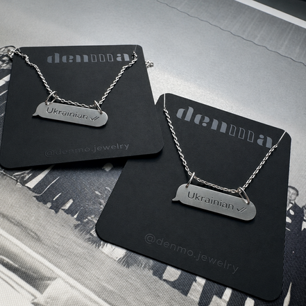Two necklaces with 'Ukrainian' pendants on black cards with 'denmo jewelry' branding.