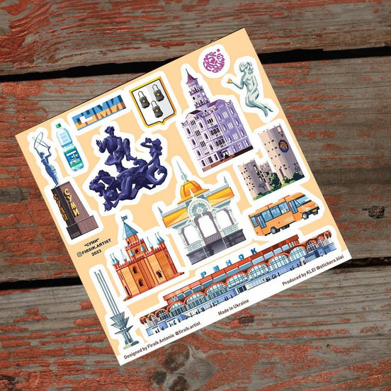 Sheet of travel-themed stickers on a wooden surface