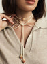Necklace with a central pendant worn by a person in a neutral setting