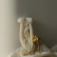 Mushroom-shaped faucet with gold handle on a neutral background