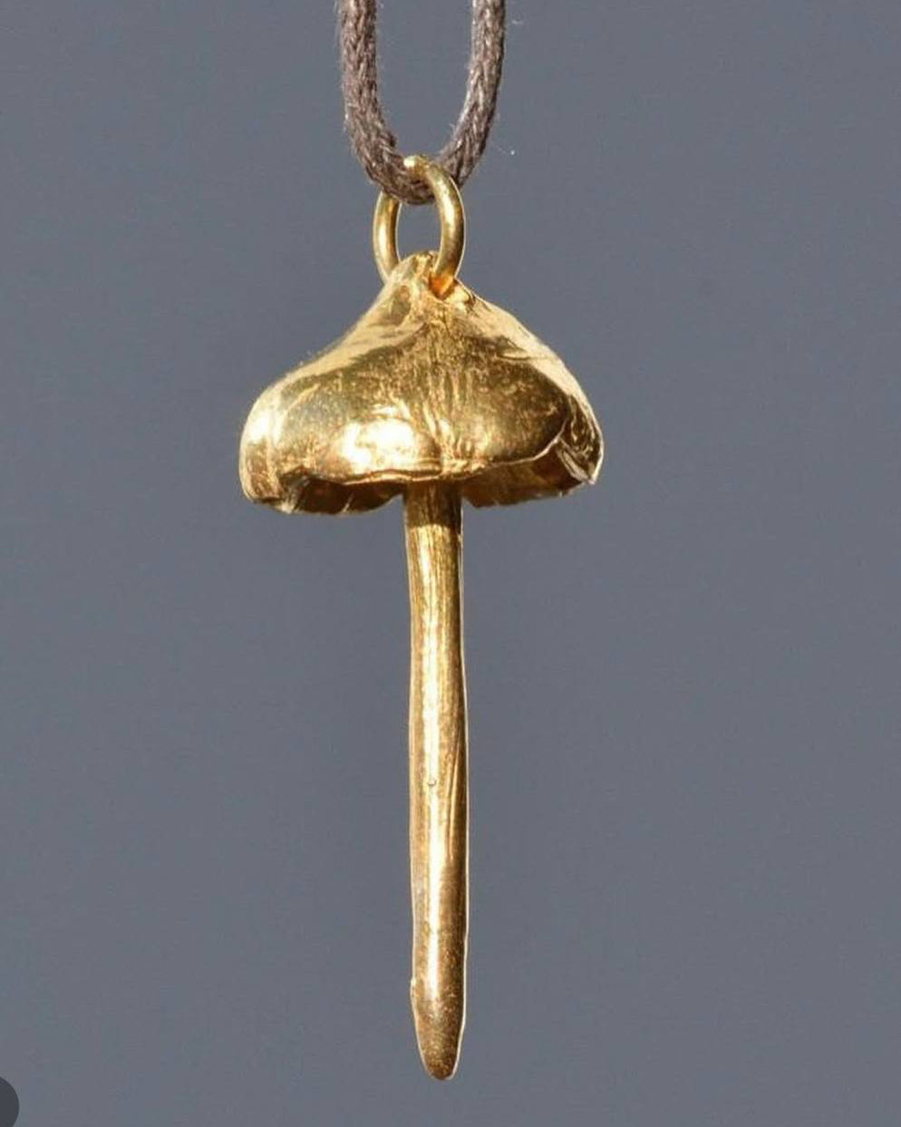 Gold pendant on a gray background