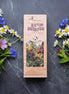 Herbal tea package with floral decorations on a dark surface