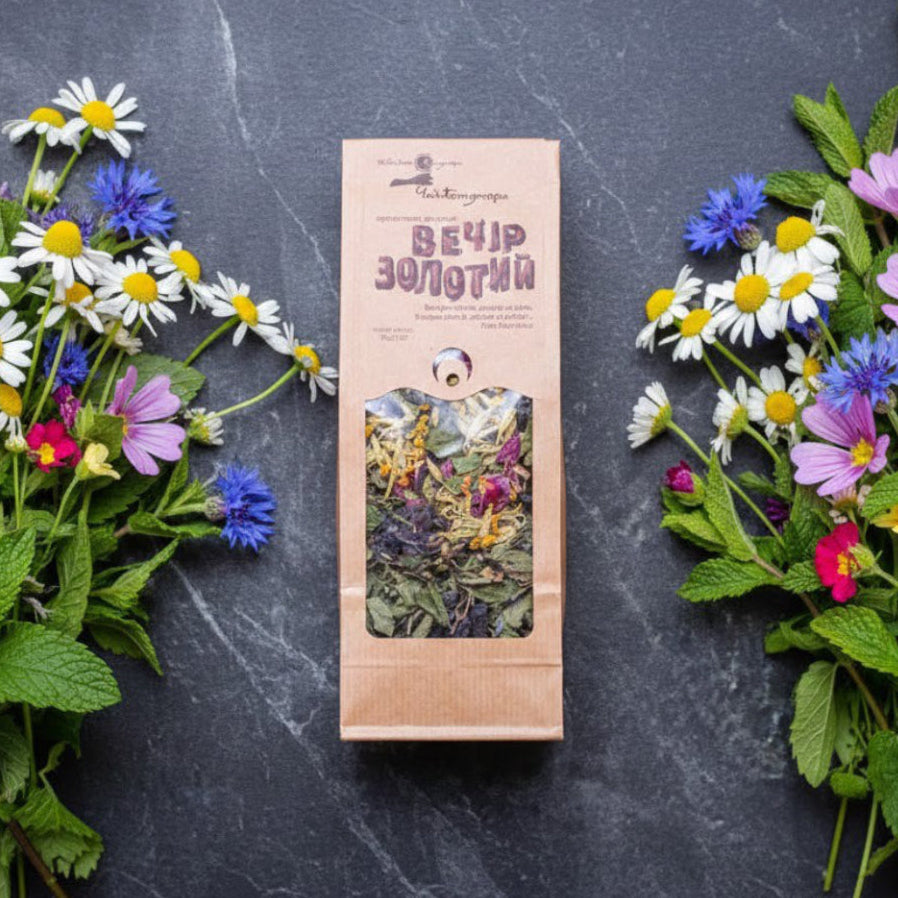 Herbal tea package with floral decorations on a dark surface
