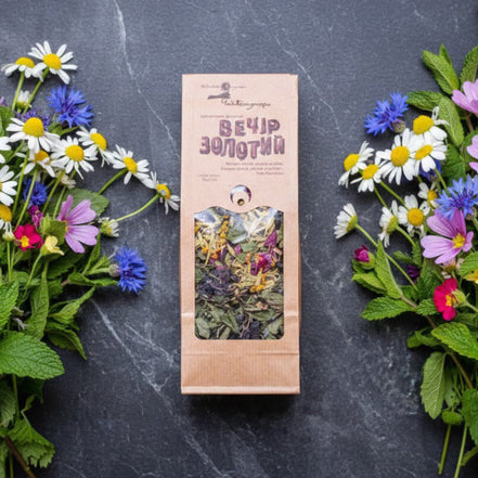 Herbal tea package with floral decorations on a dark surface