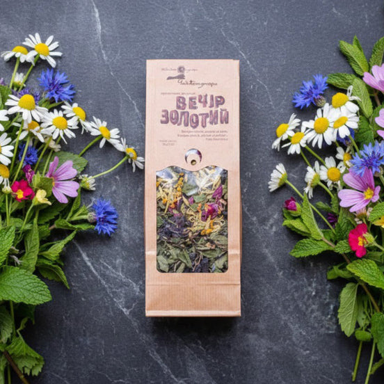 Herbal tea package with floral decorations on a dark surface